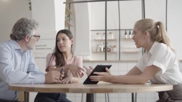 Selbstbewusste Mitarbeiter diskutieren Projekt gemeinsam im Café — Stockvideo