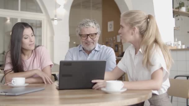 Pomyślne kobiety biznesu pokazując dane za pośrednictwem laptopa i wyjaśniając — Wideo stockowe