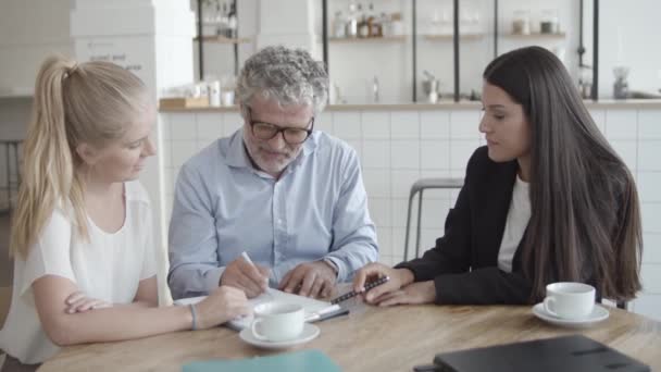 Versicherungsvertreter hilft Kunden, Formular oder Vertrag auszufüllen — Stockvideo