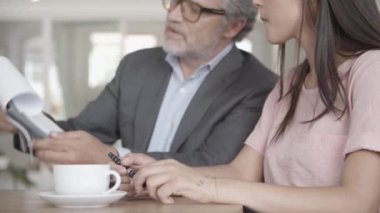 Sakallı iş adamının ortaklara kontrat göstermesi.