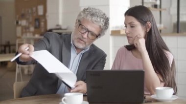 Gri saçlı kıdemli işadamı belgeyi gösteriyor