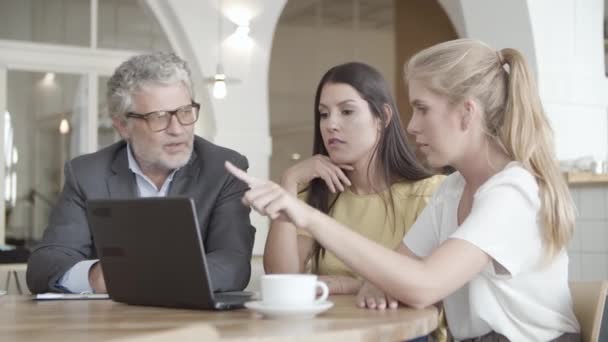 Tři profesionální partneři sedí u stolu a diskutují o dohodě — Stock video