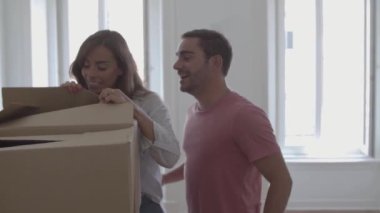 Genç çift yastıklı ve gülümseyen bir kutu açıyor.