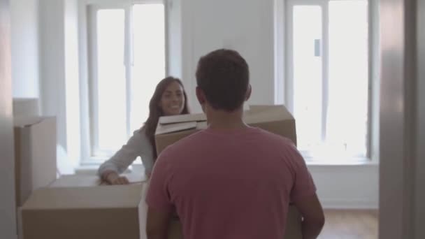 Boldog ember jön a szobába, kezében doboz különböző dolgokat — Stock videók