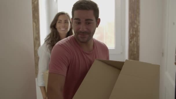 Молодой человек и женщина приходят в новый дом или квартиру — стоковое видео