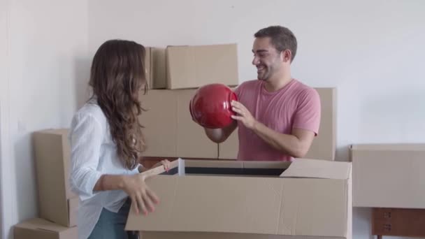 Giovane coppia disimballaggio scatole di cartone con roba — Video Stock