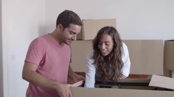 Feliz pareja desempacando cajas de cartón con cosas — Vídeos de Stock