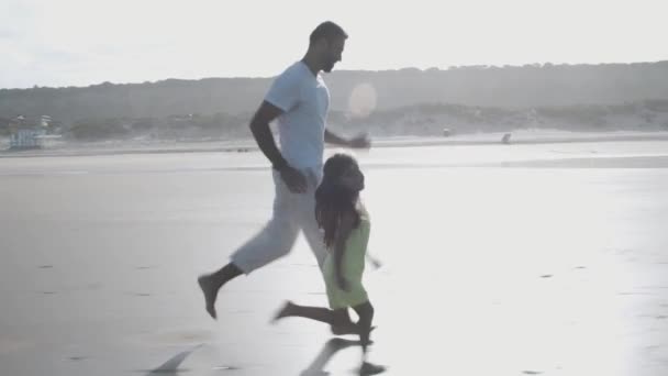 Apa és a kislánya a parton futnak a vízhez. — Stock videók