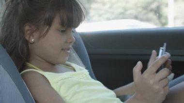 Neşeli kız arabaya biniyor, destek koltuğunda oturuyor.