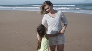 Neşeli anne ve sevimli siyah saçlı kız sarılıyor.