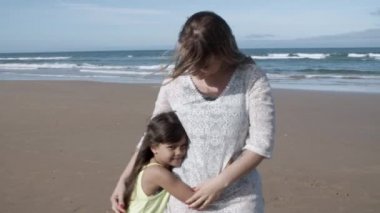 Mutlu anne ve sevimli siyah saçlı kız sarılıyor