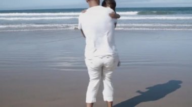 Tatlı kız sahilde mutlu babasına koşuyor.