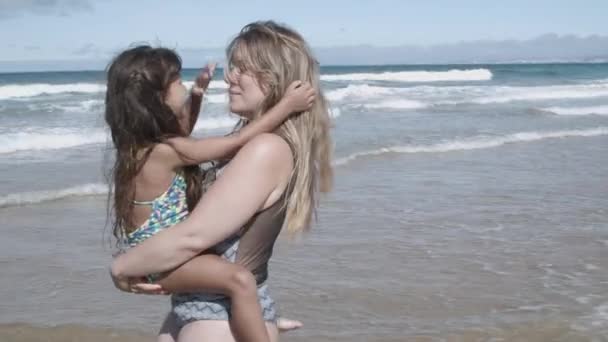 Ευτυχισμένη μαμά με μαγιό που κρατάει την κορούλα της αγκαλιά. — Αρχείο Βίντεο