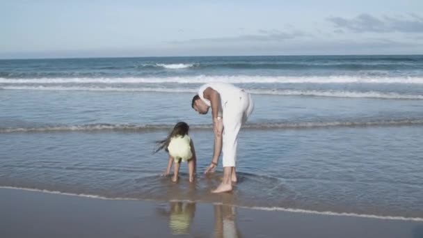 Père et petite fille passent du temps libre sur la plage — Video