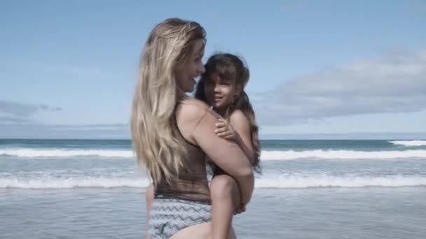 Χαρούμενη μαμά με μαγιό που κρατάει την κορούλα της αγκαλιά. — Αρχείο Βίντεο