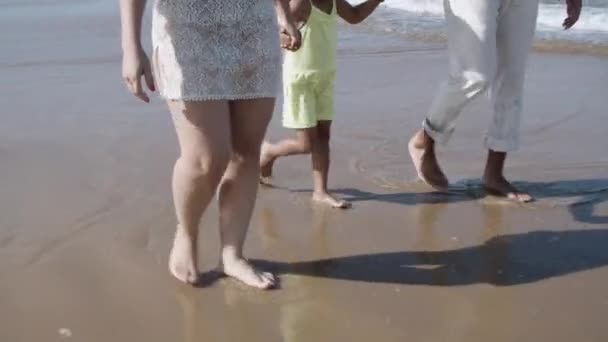 Ouders paar en kind wandelen op het strand — Stockvideo