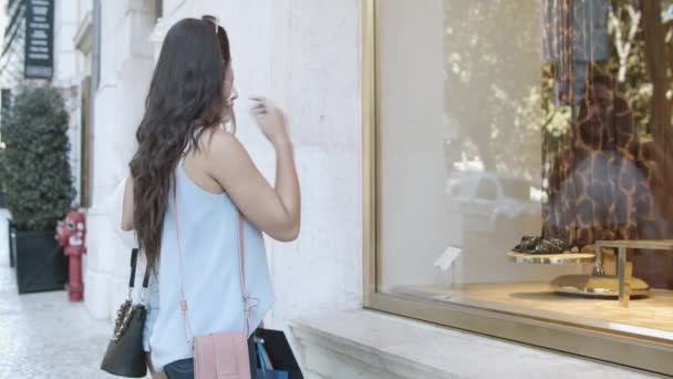 Привлекательные молодые женщины, стоящие у витрины и обсуждающие — стоковое видео