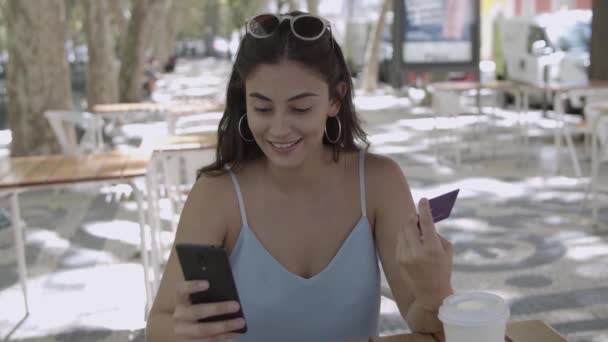 Mulher bonita fazendo pagamento com cartão de plástico via smartphone — Vídeo de Stock