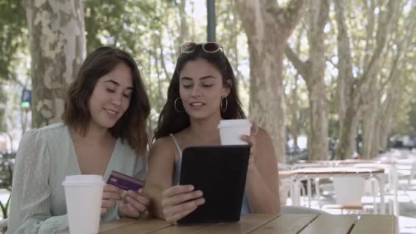 Jovens alegres pagando com cartão de plástico via tablet — Vídeo de Stock