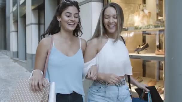 Deux femmes heureuses faisant du shopping ensemble et marchant — Video