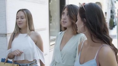 Alışveriş torbalarıyla caddede duran çekici genç bayan.