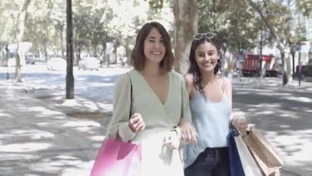 Deux jolies femmes marchant avec des sacs à provisions le long de la rue — Video