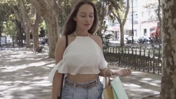 Wanita muda kaukasia memegang tas di siku dan berjalan — Stok Video
