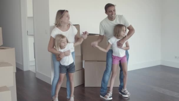 Ouders en kinderen dansen in hun nieuwe appartement — Stockvideo