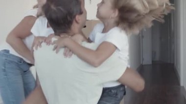 İki kız babaya koşup ona sarılıyorlar.