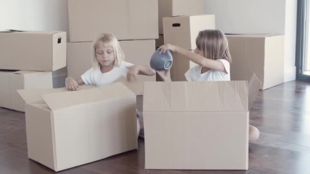 Süße hübsche Mädchen packen in neuer Wohnung aus — Stockvideo