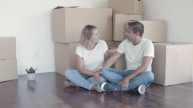 Kutuların yanında oturan neşeli çift.