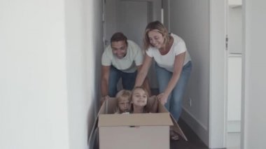 Neşeli ebeveynler ve çocuklar taşınırken eğleniyorlar