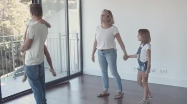 Yeni dairelerine bakan iki çocuklu mutlu bir aile.