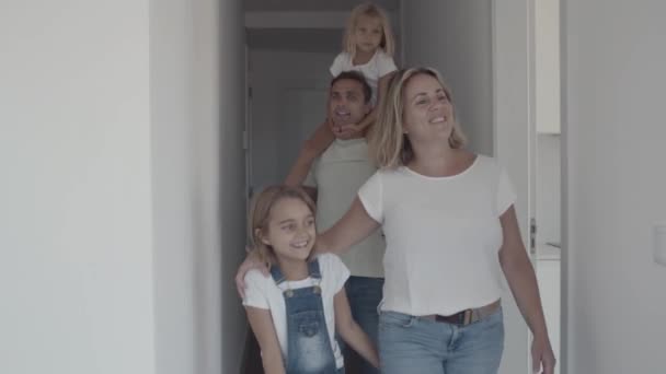 Šťastný rodinný pár se dvěma dětmi přichází do nového bytu — Stock video