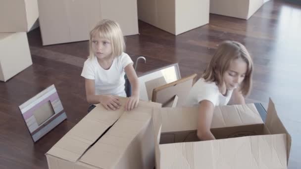 Yeni dairede bavulları açan küçük kız kardeşler. — Stok video