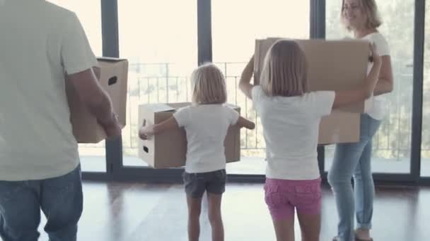 Padres y dos hijos entrando en un apartamento vacío — Vídeo de stock