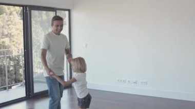 Mutlu ebeveynler ve aktif çocuklar yeni boş dairede eğleniyorlar.