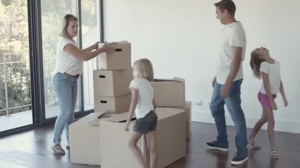 Šťastní rodiče a dvě dívky stěhují do nového bytu — Stock video