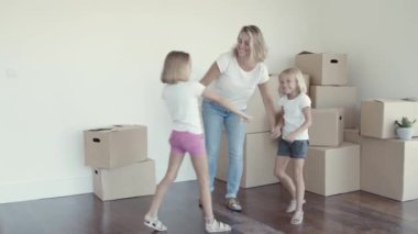 Mutlu anne kızlarıyla dans ediyor.