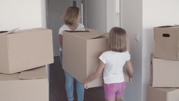 Мама и дочь несут коробку с мультфильмами — стоковое видео