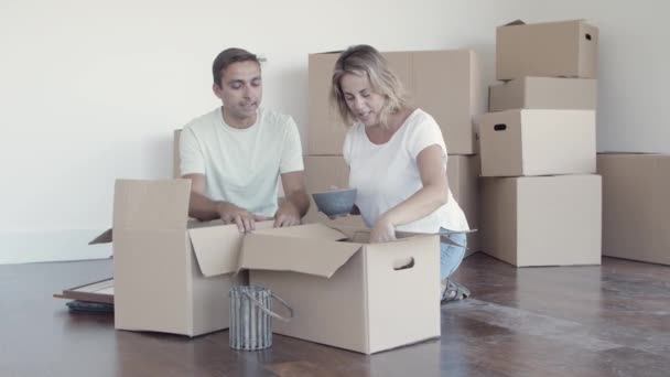 Casal feliz embalando coisas para mover — Vídeo de Stock