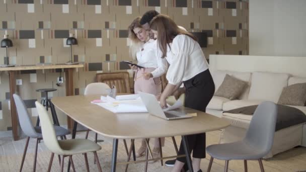 Werkgroepvergadering aan tafel met laptop en blauwdruk — Stockvideo