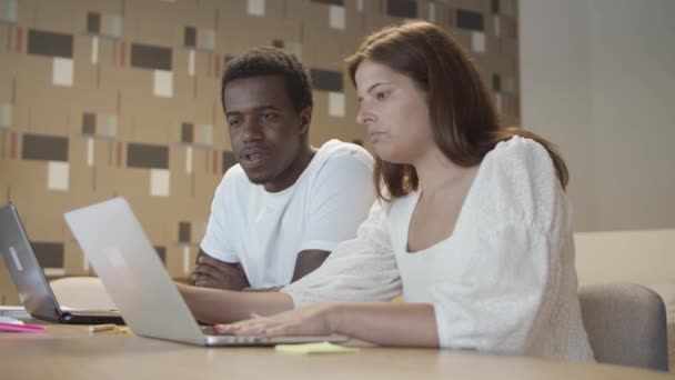 Diverse paar professionals zitten aan tafel met laptops — Stockvideo