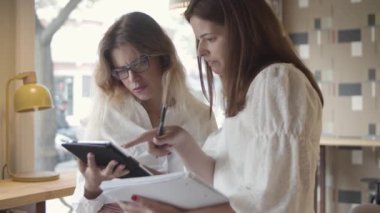 Tablet üzerindeki sunumu izleyen odaklanmış iş arkadaşları