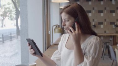 Cep telefonuyla konuşan ciddi, güzel bir genç kadın.