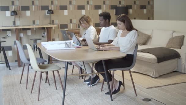 Grupo de profissionais sentados juntos à mesa — Vídeo de Stock