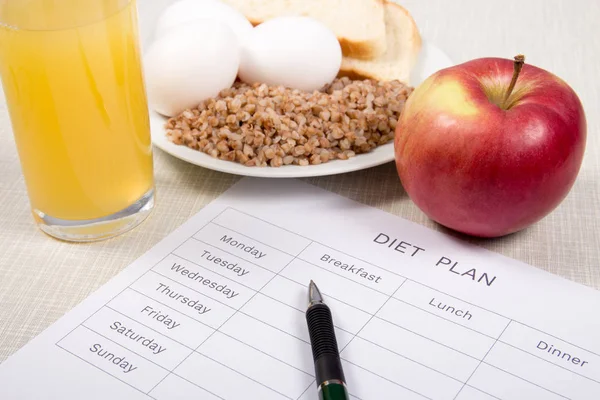 Diet plan with buckwheat,bread,eggs,apple and a glass of orange juice.Diet concept