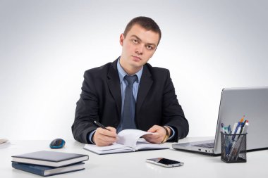 Belgeleri ve dizüstü bilgisayar ile gri bir arka plan üzerinde çalışma iş adamı