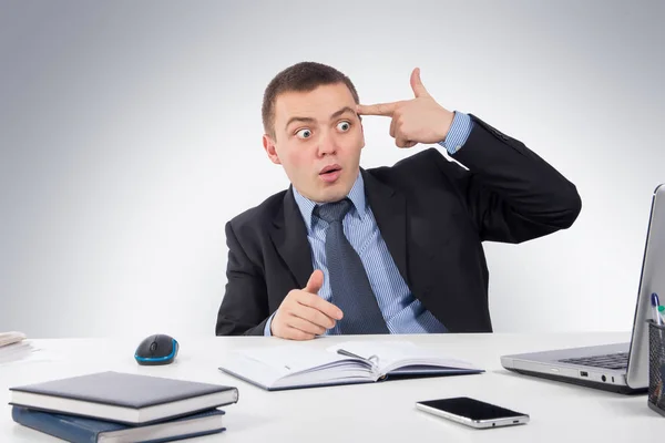 Kafasına anda gri arka plan üzerinde onun bilgisayar önünde haber aldıktan sonra ateş kendini onun parmak işaret ofis, iş, teknoloji, finans ve Internet kavramı-genç şok umutsuz iş adamı