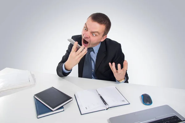 Business, people, stress concept - close up of angry businessman with smartphone shouting on gray background